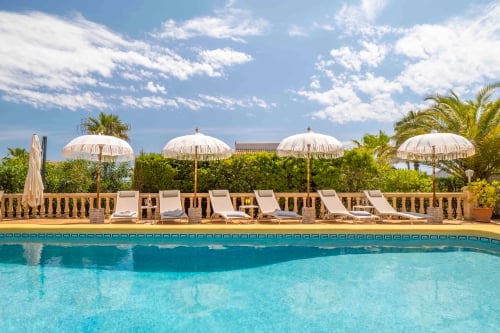 Loungezone met parasols aan het zwembad