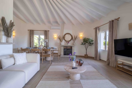 Woonkamer met zithoek, eettafel en uitzicht op de tuin
